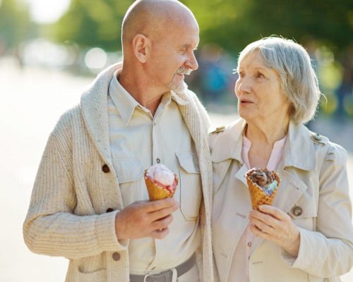 Seniors with ice-cream Amorous seniors with ice-cream taking walk